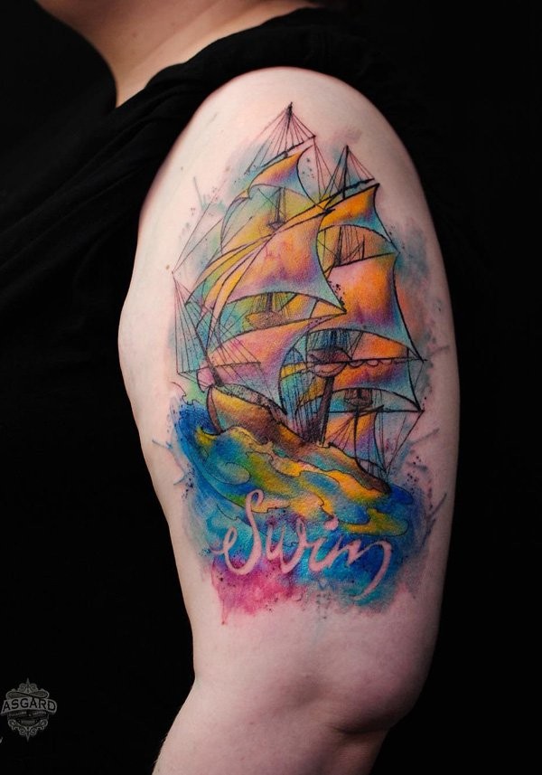 Watercolor style beautiful looking shoulder tattoo of sailing ship with lettering