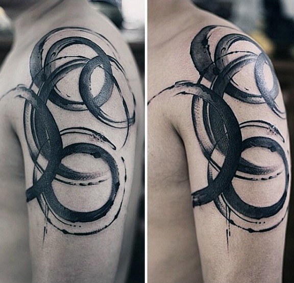 Watercolor style black ink shoulder tattoo of various circles