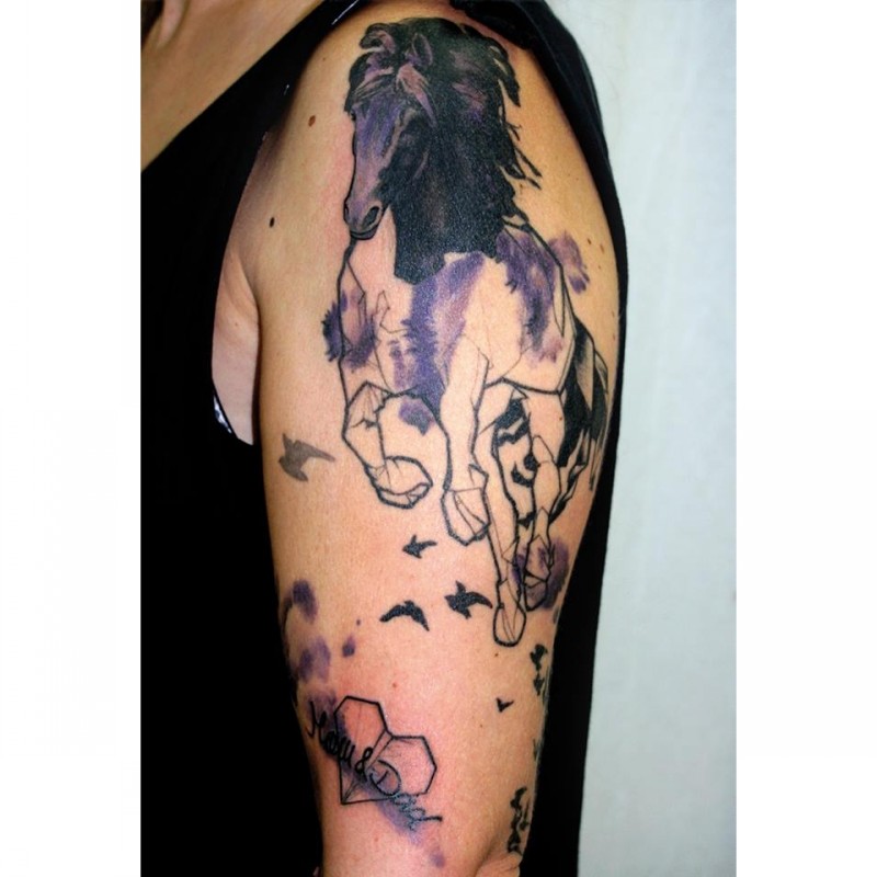 Watercolor style colored shoulder tattoo of running horse with birds and lettering