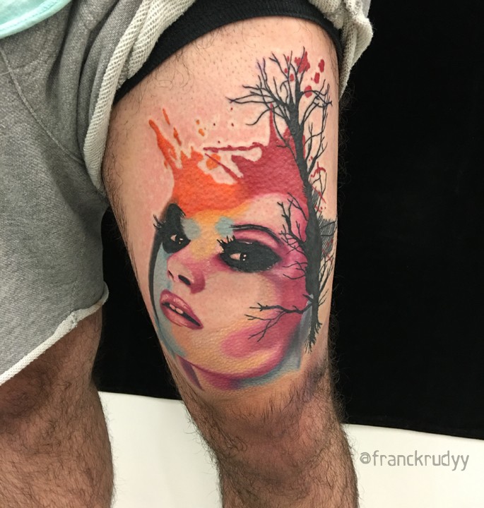 Watercolor style colored thigh tattoo of woman with big tree