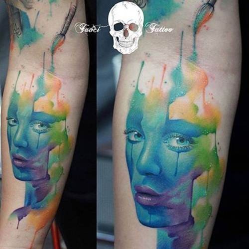Watercolor style colorful woman portrait tattoo on arm