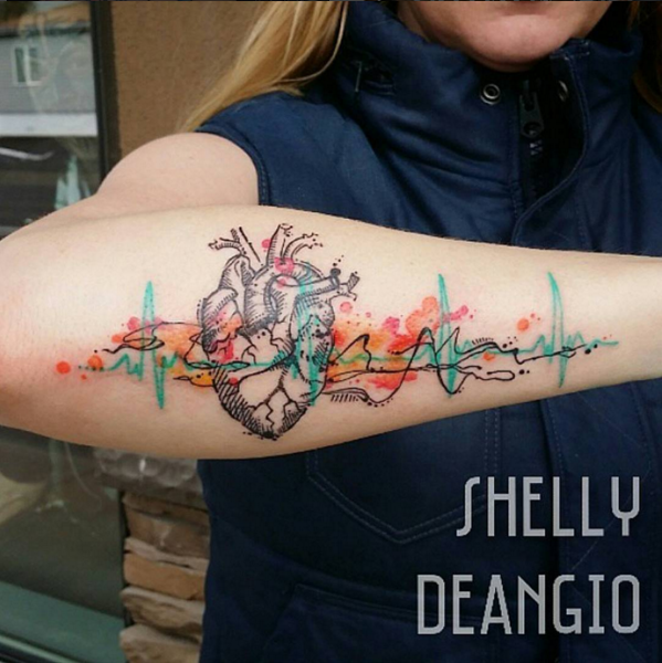 Watercolor style forearm tattoo of human heart