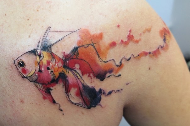 Watercolor style interesting looking golden fish tattoo on back