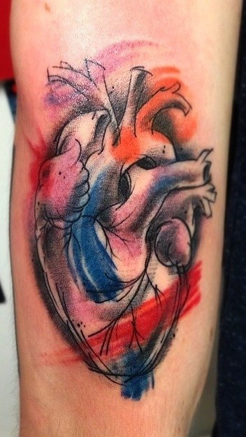 Watercolor style interesting looking human heart tattoo on forearm