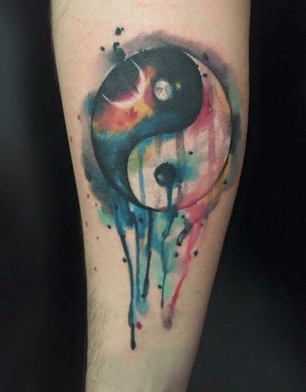 Watercolor style medium size Yin Yang symbol tattoo on forearm