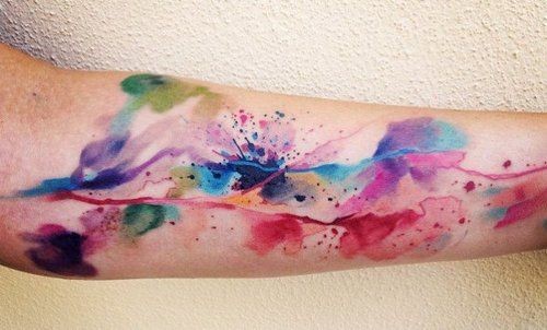 Watercolor style painted abstract floral tattoo on arm