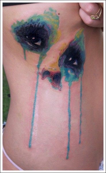 Watercolor style painted multicolored mystical eyes tattoo on chest