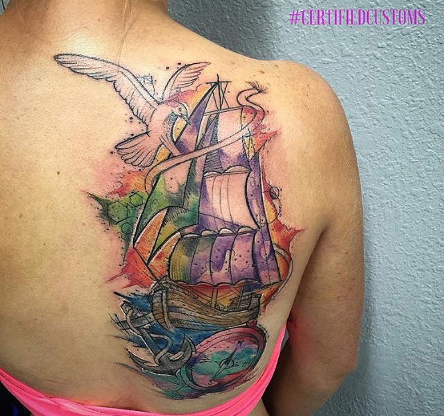Watercolor style shoulder tattoo of sailing ship, compass and bird