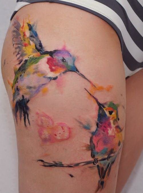 Tatuaggio pittoresco sulla gamba i colibrì colorati