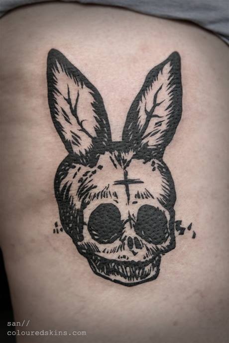 Weird dark black ink skull with bunny ears tattoo in homemade style