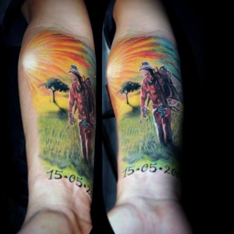 stile occidentale colorato uomo su prato con i dati tatuaggio su braccio