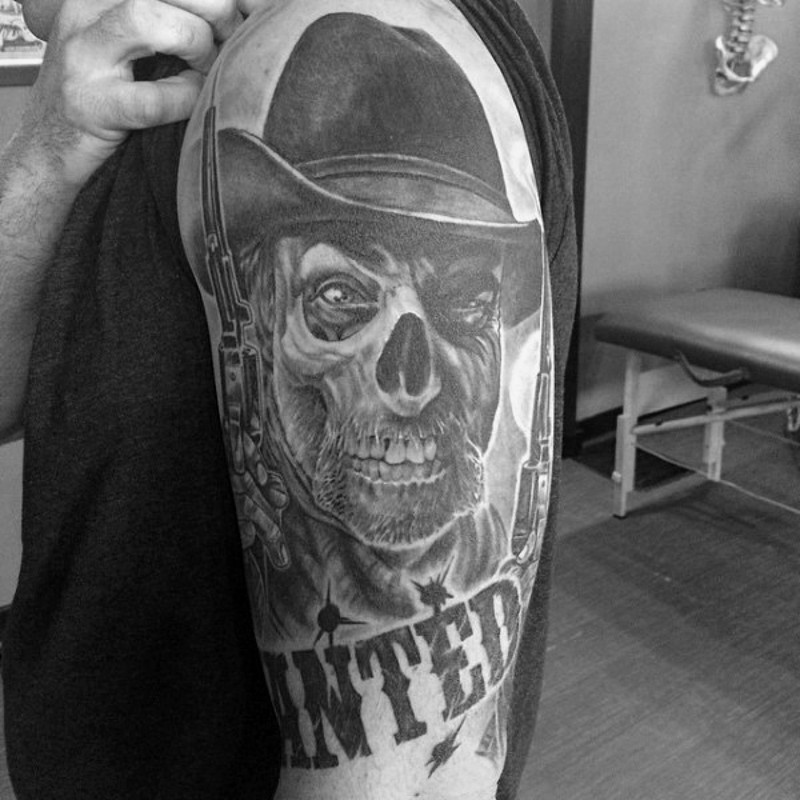Tatuaje en el brazo, cráneo de vaquero con pistola