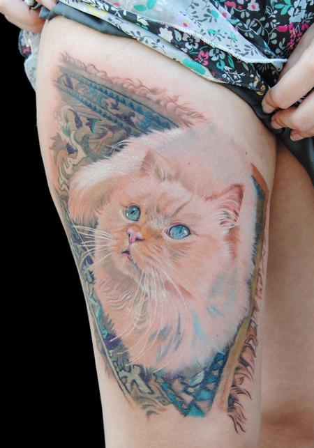 Tatuaje en la pierna, gato crema en la alfombra