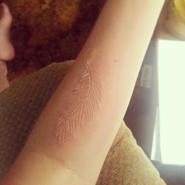 White ink feather forearm tattoo