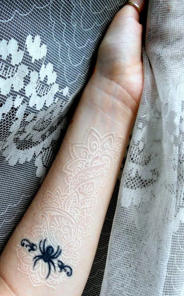 White ink lace and black spider forearm tattoo