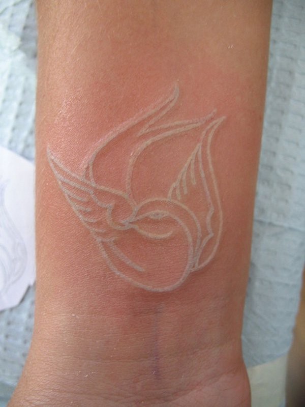 Weiße Tinte kleiner Vogel Tattoo am Handgelenk