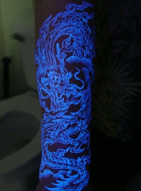 Tatuaje en el antebrazo,
dragón de estilo asiático, tinta ultravioleta