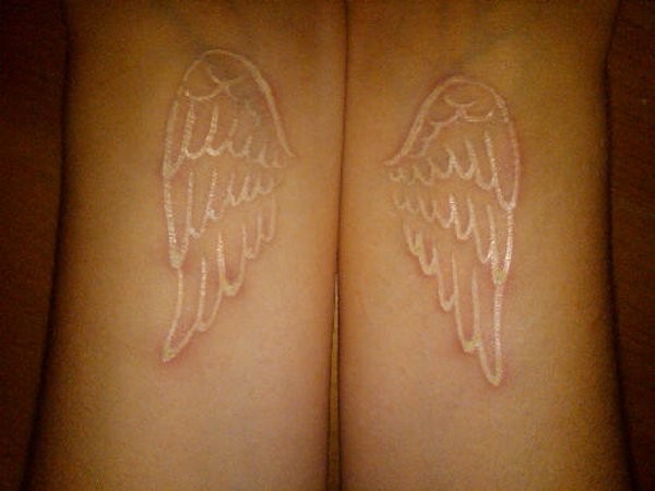 White ink wings tattoo on wrist