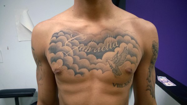 Weiße Taube im Himmel  graues Gedenk Tattoo an der Brust mit Schriftzug