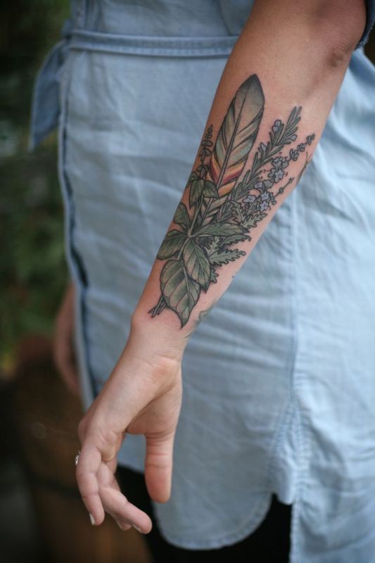 Tatuaje en el antebrazo,
 bouquet de flores silvestres y pluma de una ave