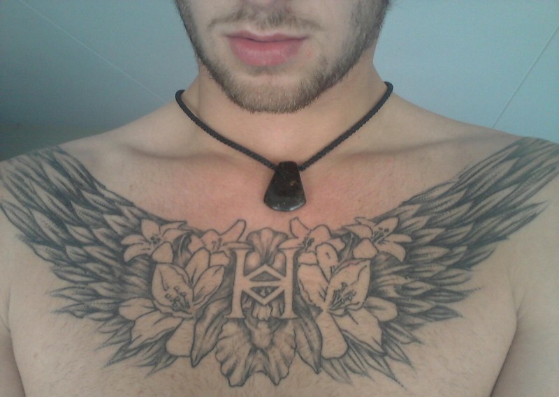 Flügel mit Anagramm und Blumen Tattoo an der Brust