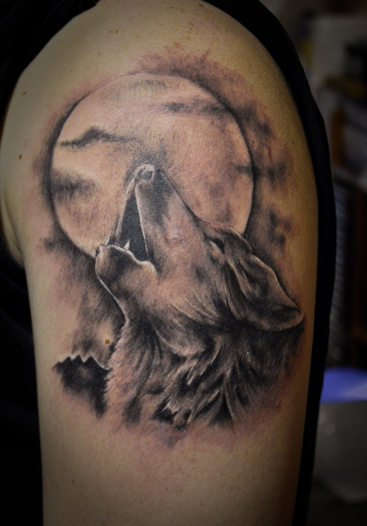 Tatuaggio colorato sul deltoide il lupo che ulula alla luna
