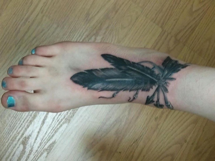 Women arrow tattoo and feathers on foot