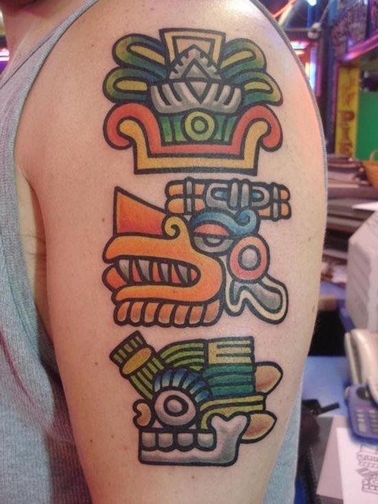 Tatuaje  de dibujos aztecas de varios colores en el brazo