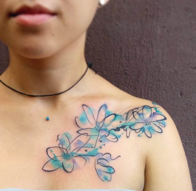 Wunderbare blaue und violette  farbige Blumen Tattoo an der Schulter im Aquarell-Stil
