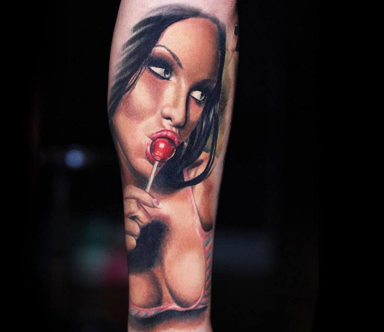 Wonderful colored and detailed sexy woman on forearm tattoo with lollipop
