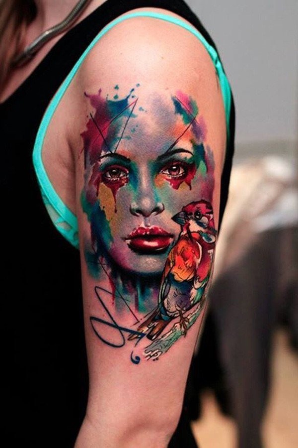 Wunderschönes farbiges im Aquarell Stil abstraktes Porträt Tattoo der Frau auf der Schulter mit kleinem Vogel