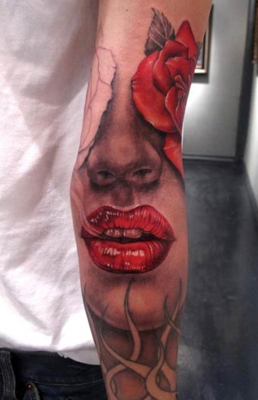 Tatuaje en el antebrazo, cara de mujer con labios rojos y rosa