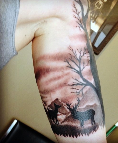 Wonderful looking realistic black and gray style biceps tattoo of deers in wild life