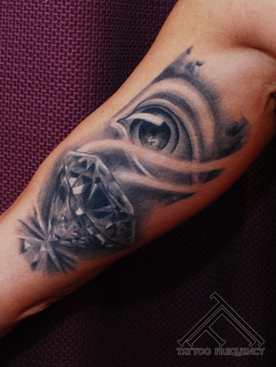 Tatuaje en el brazo,
ojo con diamante precioso, colores negro y blanco