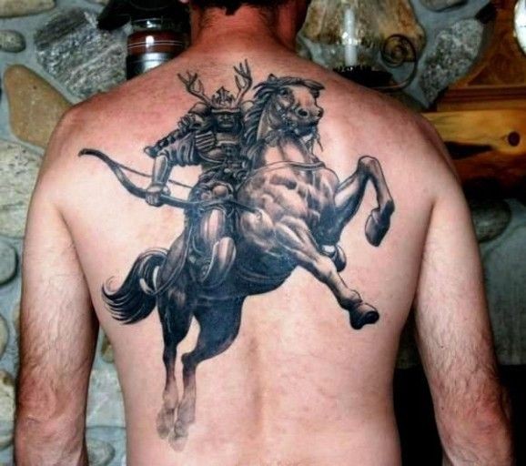Tatuaje en la espalda,
guerrero va a caballo