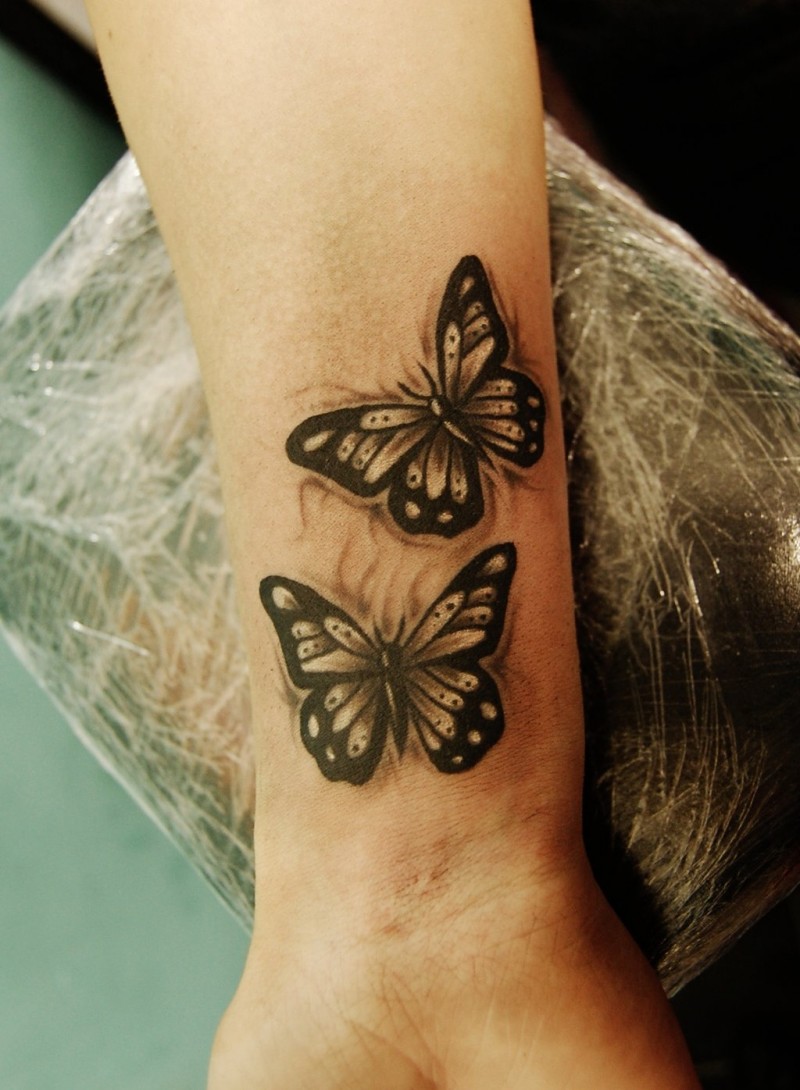 Tatuaje en la muñeca, mariposas de colores megro y blanco