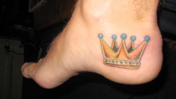 Yellow crown tattoo on foot