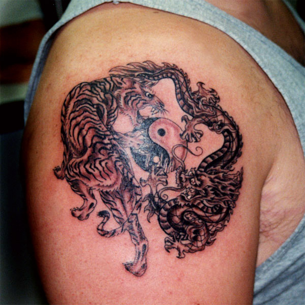 Tatuaje en el brazo, yin yang, dos dragones