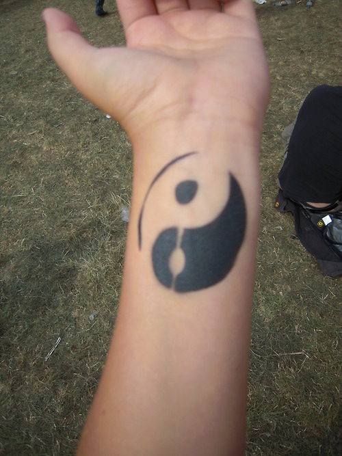 Tatuaggio sul polso il disegno nero in stile Yin-Yang
