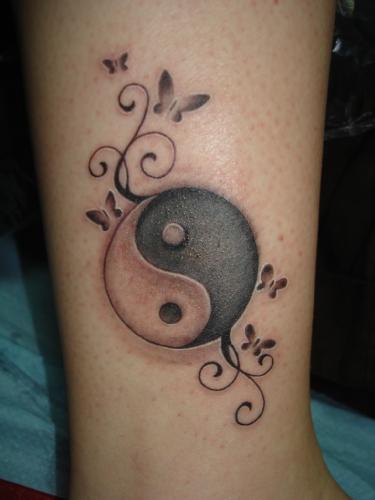 Tatuaje en la pierna, yin yang con pequeños rizos